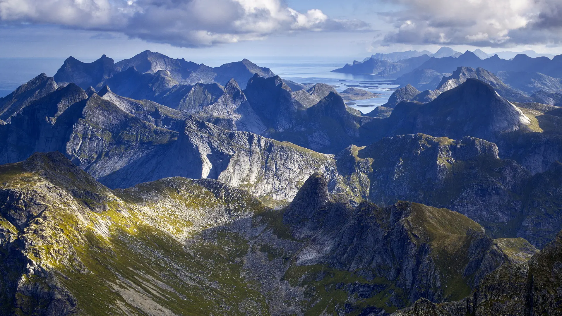 Mountain ridgelines and peaks at Hermannsdalstinden in the Lofoten Islands, Norway, along a demanding high-elevation hiking route.