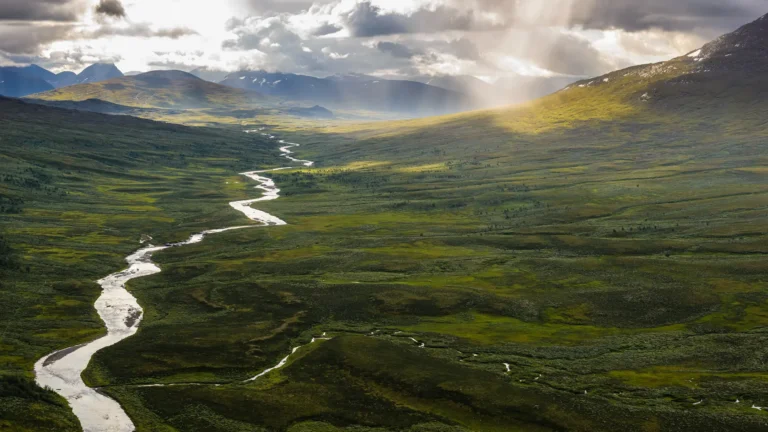 Mountain valley landscape in Lapland with a winding river across open terrain.